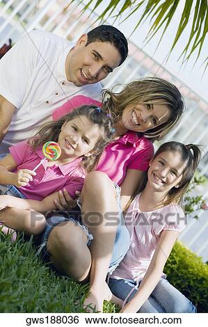 Portrait of a mid adult man and a young woman smiling with two girls View Large Photo Image Stock Photograph - Portrait of a mid adult man and a young woman smiling with two girls. Fotosearch