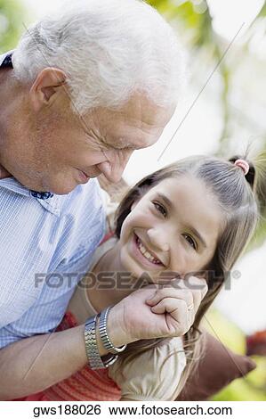 Portrait of a senior man pinching on her granddaughter's cheek View Large Photo Image Stock Photograph - Portrait of a senior man pinching on her granddaughter's cheek. Fotosearch