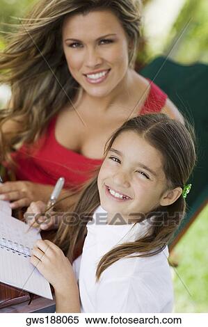 Portrait of a young woman teaching a girl and smiling View Large Photo Image Stock Photography - Portrait of a young woman teaching a girl and smiling. Fotosearch