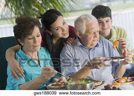 Stock Photo - Senior couple having lunch with their grandchildren. Fotosearch