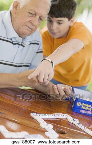 Senior man playing domino with his grandson View Large Photo Image Stock Photo - Senior man playing domino with his grandson. Fotosearch