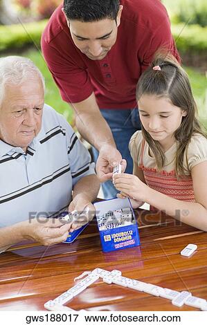Senior man playing domino with his granddaughter and son View Large Photo Image Stock Photo - Senior man playing domino with his granddaughter and son. Fotosearch