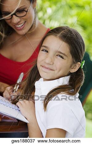 Young woman teaching a girl and smiling View Large Photo Image Stock Photo - Young woman teaching a girl and smiling. Fotosearch