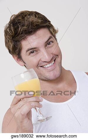Portrait of a mid adult man holding a glass of orange juice View Large Photo Image Stock Image - Portrait of a mid adult man holding a glass of orange juice. Fotosearch