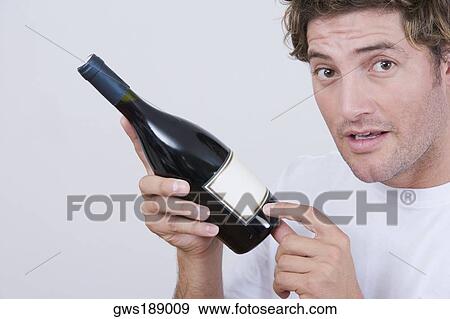 Portrait of a mid adult man holding a champagne bottle View Large Photo Image Stock Photo - Portrait of a mid adult man holding a champagne bottle. Fotosearch