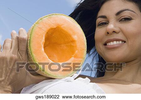 Portrait of a mid adult woman holding a half melon and smiling View Large Photo Image Stock Image - Portrait of a mid adult woman holding a half melon and smiling. Fotosearch