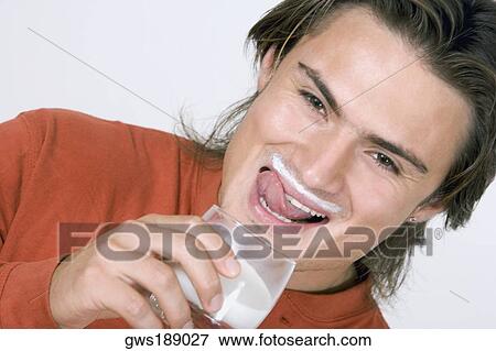 Portrait of a young man drinking milk and smiling View Large Photo Image Stock Photo - Portrait of a young man drinking milk and smiling. Fotosearch