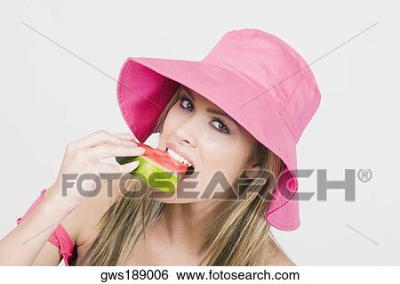 Portrait of a young woman eating a watermelon View Large Photo Image Stock Photograph - Portrait of a young woman eating a watermelon. Fotosearch