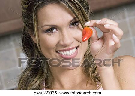 Portrait of a young woman holding a red chili pepper and smiling View Large Photo Image Stock Photography - Portrait of a young woman holding a red chili pepper and smiling. Fotosearch