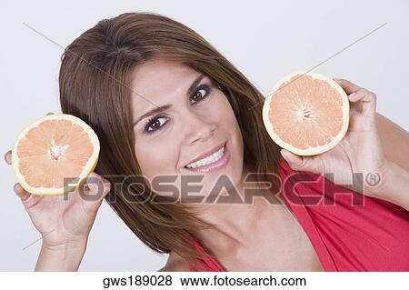 Portrait of a young woman holding slices of oranges View Large Photo Image Stock Photo - Portrait of a young woman holding slices of oranges. Fotosearch