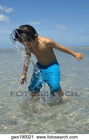 Stock Image - Boy playing on the beach. Fotosearch