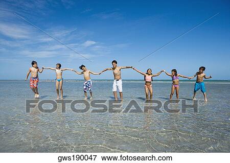 Children playing with holding each other hands on the beach View Large Photo Image Stock Photo - Children playing with holding each other hands on the beach. Fotosearch