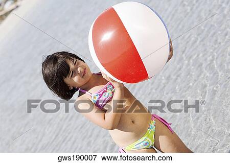 Girl holding a beach ball on the beach View Large Photo Image Stock Photo - Girl holding a beach ball on the beach. Fotosearch