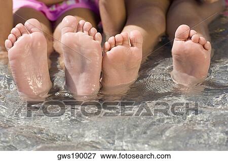Low section view of two girls sitting in water View Large Photo Image Stock Photo - Low section view of two girls sitting in water. Fotosearch