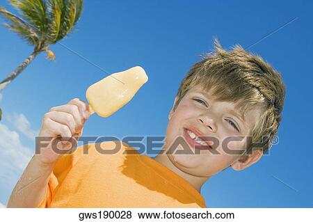 Portrait of a boy holding an ice-cream and smiling View Large Photo Image Stock Photo - Portrait of a boy holding an ice-cream and smiling. Fotosearch