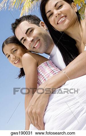 Portrait of a mid adult couple smiling with their daughter View Large Photo Image Stock Image - Portrait of a mid adult couple smiling with their daughter. Fotosearch