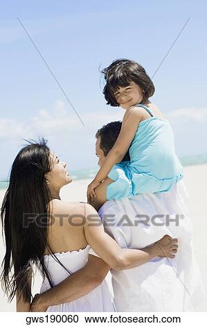 Rear view of a mid adult man carrying his daughter on his shoulders with a mid adult woman beside them View Large Photo Image Stock Image - Rear view of a mid adult man carrying his daughter on his shoulders with a mid adult woman beside them. Fotosearch
