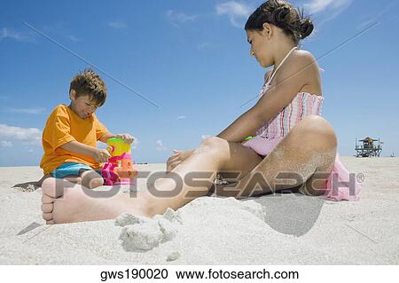 Side profile of a girl and a boy playing on the beach View Large Photo Image Stock Image - Side profile of a girl and a boy playing on the beach. Fotosearch