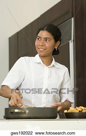 Maid preparing food in the kitchen and smiling View Large Photo Image Stock Image - Maid preparing food in the kitchen and smiling. Fotosearch