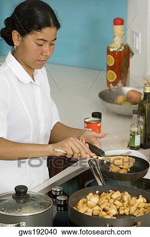 Stock Image - Maid preparing food in the kitchen. Fotosearch