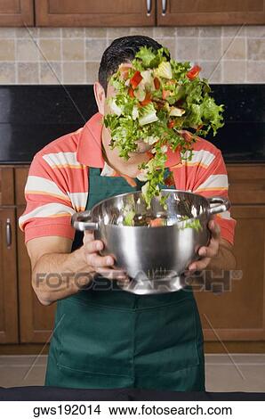Mid adult man mixing salad in a mixing colander View Large Photo Image Picture - Mid adult man mixing salad in a mixing colander. Fotosearch