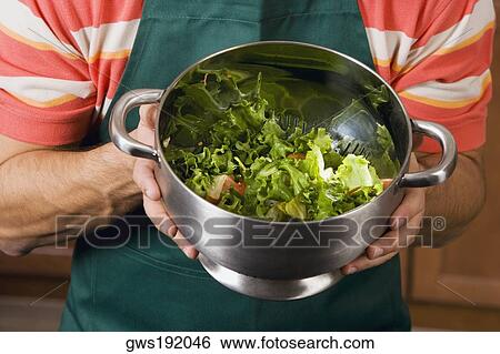 Mid section view of a man mixing salad in a colander View Large Photo Image Stock Photograph - Mid section view of a man mixing salad in a colander. Fotosearch