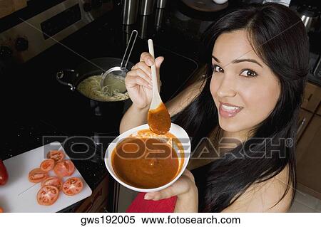 Portrait of a young woman holding a bowl of tomato soup in the kitchen View Large Photo Image Stock Photography - Portrait of a young woman holding a bowl of tomato soup in the kitchen. Fotosearch