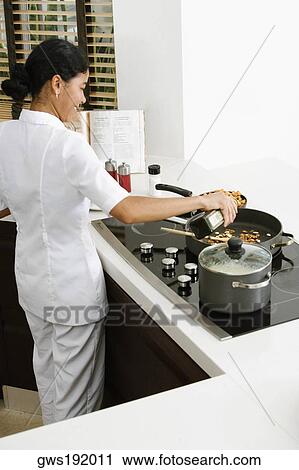 Rear view of a maid preparing food in the kitchen and smiling View Large Photo Image Stock Image - Rear view of a maid preparing food in the kitchen and smiling. Fotosearch