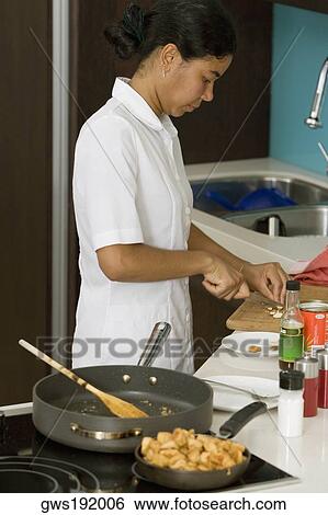 Side profile of a maid preparing food in the kitchen View Large Photo Image Stock Photograph - Side profile of a maid preparing food in the kitchen. Fotosearch