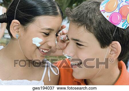Close-up of a boy and his sister smiling with cake on their faces View Large Photo Image Stock Photo - Close-up of a boy and his sister smiling with cake on their faces. Fotosearch