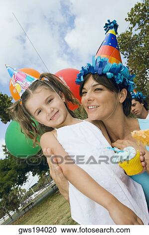 Close-up of a girl standing with her mother and smiling View Large Photo Image Stock Image - Close-up of a girl standing with her mother and smiling. Fotosearch