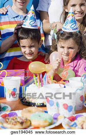 Girl with her friends standing in front of a birthday cake View Large Photo Image Stock Photography - Girl with her friends standing in front of a birthday cake. Fotosearch