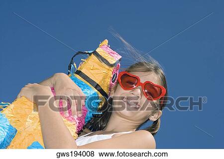 Low angle view of a girl holding a rocking horse and smiling View Large Photo Image Stock Photo - Low angle view of a girl holding a rocking horse and smiling. Fotosearch