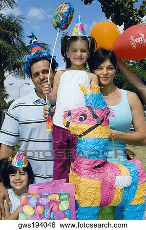 Mid adult couple with their daughters celebrating a birthday party View Large Photo Image Stock Photograph - Mid adult couple with their daughters celebrating a birthday party. Fotosearch
