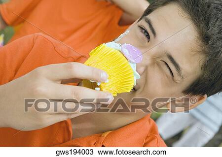 Portrait of a boy eating a cupcake View Large Photo Image Stock Image - Portrait of a boy eating a cupcake. Fotosearch