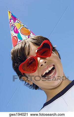 Stock Image - Portrait of a boy wearing sunglasses and laughing. Fotosearch