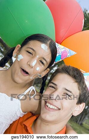 Portrait of a boy with his sister wearing birthday hats and smiling View Large Photo Image Stock Image - Portrait of a boy with his sister wearing birthday hats and smiling. Fotosearch