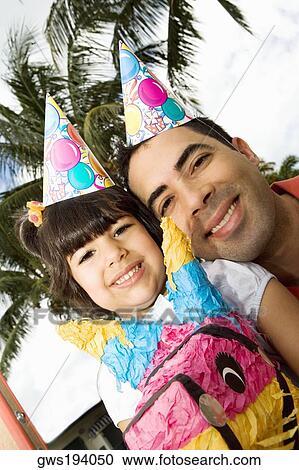 Stock Image - Portrait of a girl sitting on a rocking horse and smiling with her father. Fotosearch
