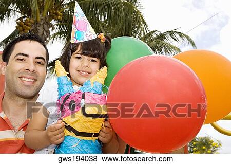 Stock Photo - Portrait of a girl sitting on a rocking horse and smiling with her father. Fotosearch