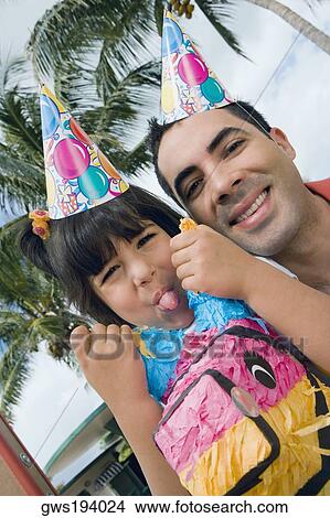 Portrait of a girl sticking her tongue out and her father smiling View Large Photo Image Picture - Portrait of a girl sticking her tongue out and her father smiling. Fotosearch
