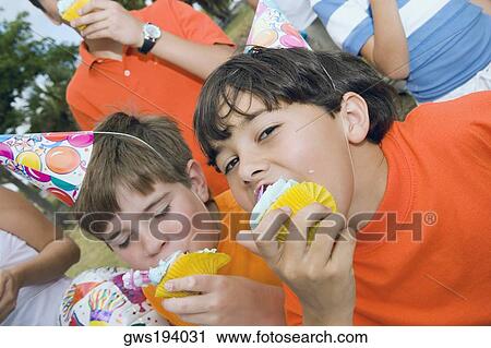 Portrait of two boys eating cupcakes View Large Photo Image Stock Image - Portrait of two boys eating cupcakes. Fotosearch