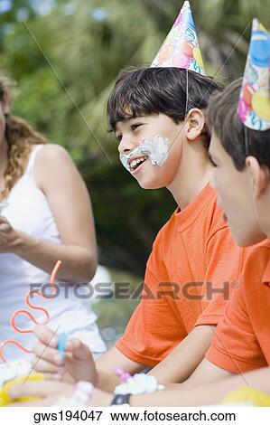 Side profile of two boys and a girl celebrating a birthday party View Large Photo Image Stock Photo - Side profile of two boys and a girl celebrating a birthday party. Fotosearch