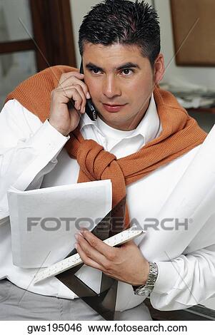 Stock Photograph - Architect holding a blueprint and talking on a mobile phone. Fotosearch