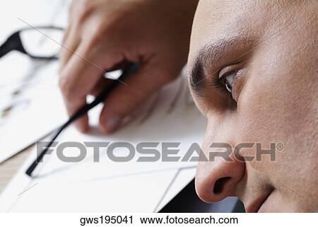 Stock Image - Close-up of a male architect resting in an office. Fotosearch