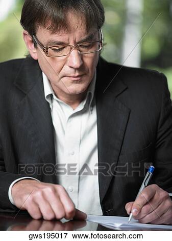 Close-up of a mature man writing on a sheet of paper View Large Photo Image Stock Photo - Close-up of a mature man writing on a sheet of paper. Fotosearch