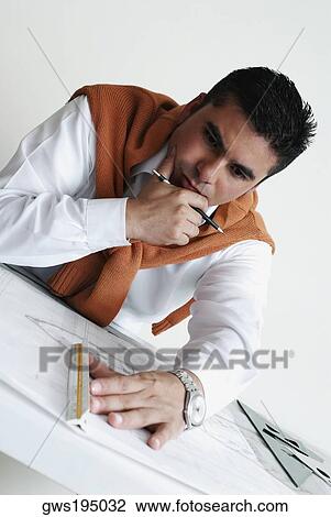 Stock Image - Close-up of an architect working on a blueprint. Fotosearch