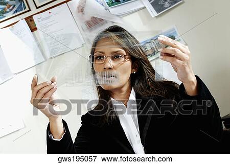 Stock Photo - Female architect looking at a blueprint. Fotosearch