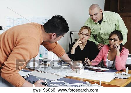 Four architects working together on a blueprint View Large Photo Image Stock Photograph - Four architects working together on a blueprint. Fotosearch