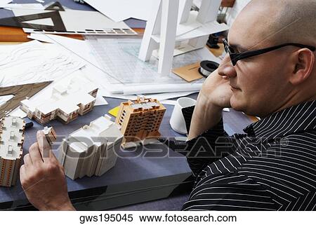 High angle view of a male architect looking at a building's model View Large Photo Image Stock Photography - High angle view of a male architect looking at a building's model. Fotosearch