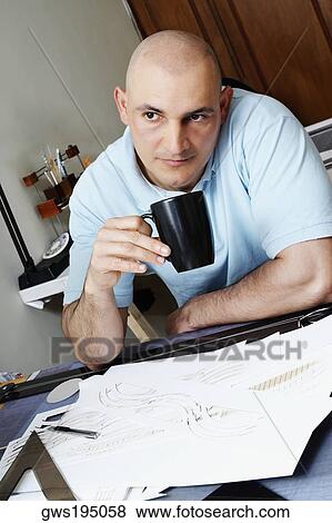 Male architect sitting in an office and drinking coffee View Large Photo Image Stock Photo - Male architect sitting in an office and drinking coffee. Fotosearch